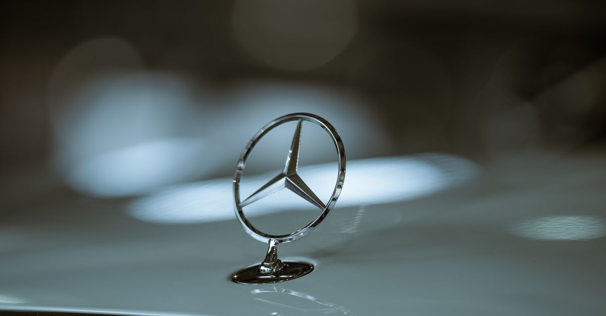 Close-up of a Mercedes-Benz emblem on a car hood, highlighting luxury and elegance.
